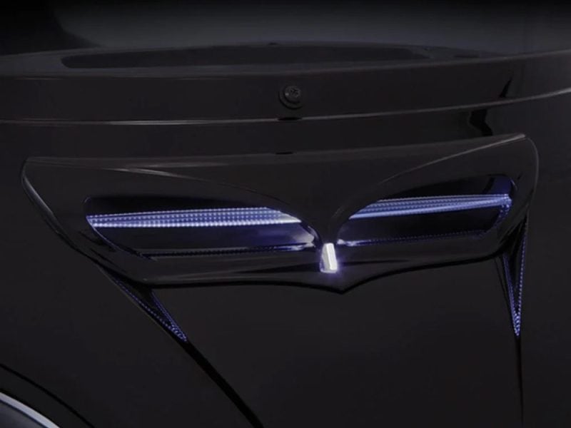 Sleek black motorcycle with illuminated LED headlights, modern design, high-performance aesthetics.