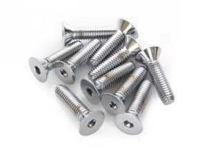 Shiny metal screws for motorcycle repair or customization on white background.