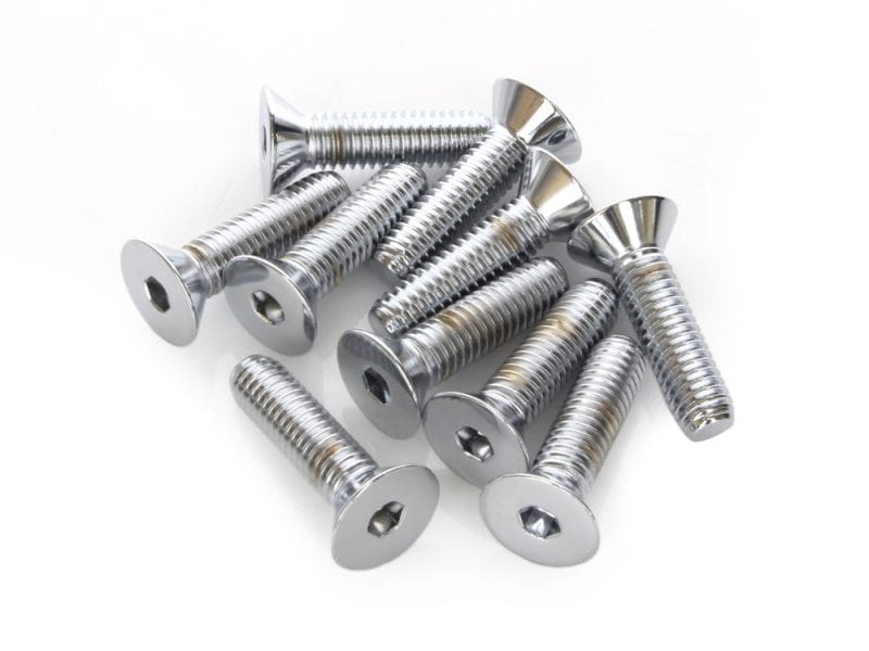Shiny metal screws for motorcycle repair or customization on white background.