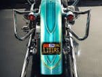 Vibrant turquoise motorcycle with chrome accents and customised license plate.