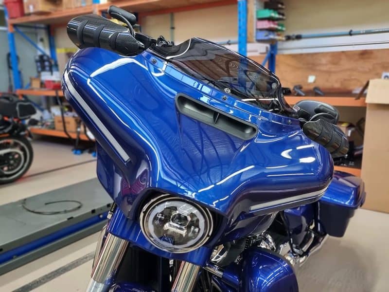 Violet blue touring motorcycle with aerodynamic fairing and advanced features.
