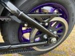 High-performance motorcycle rear wheel with purple accents and advanced suspension system.