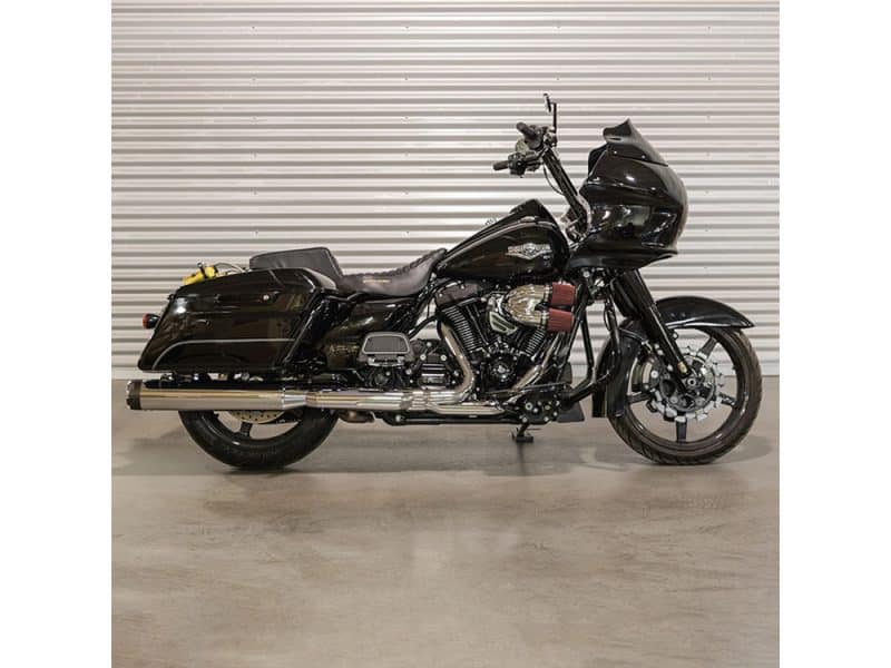 Harley-Davidson touring motorcycle in black with sleek design and custom exhaust system.