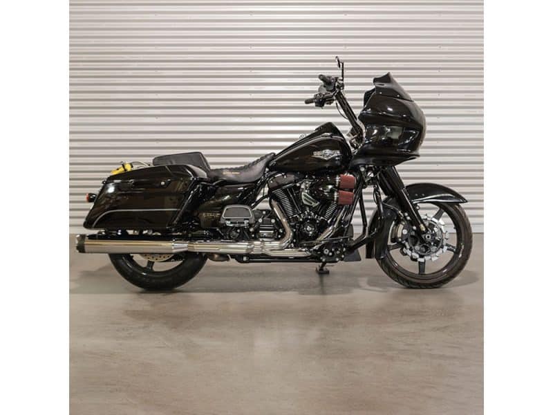 Harley Davidson touring motorcycle with black custom paint, touring fairing, and saddlebags.
