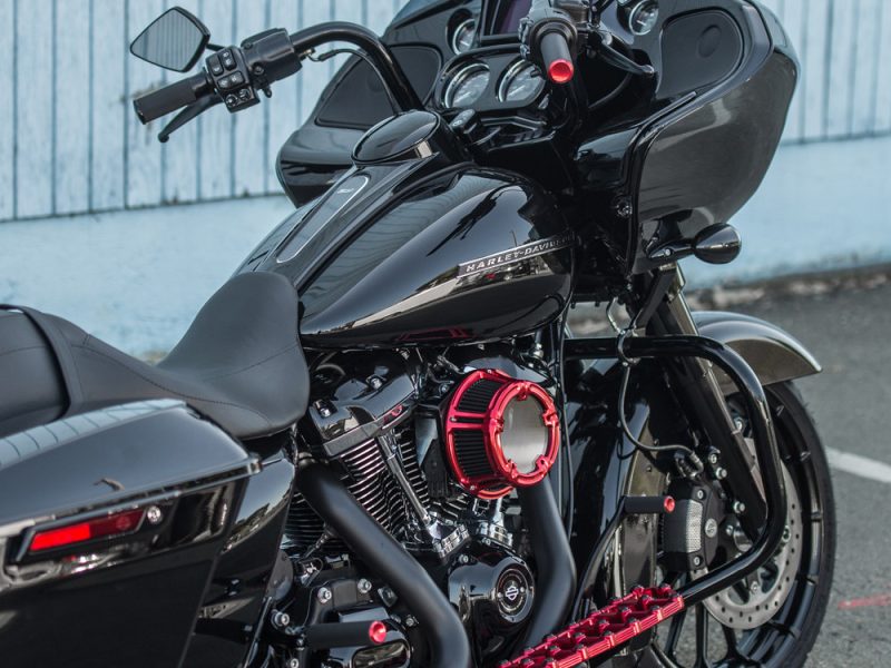 Black Harley-Davidson motorcycle with custom red accents and sleek touring design in outdoor setting.