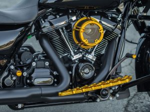 Vivid black motorcycle engine with gold accents and custom detailing, showcasing high-performance parts and alloy components.
