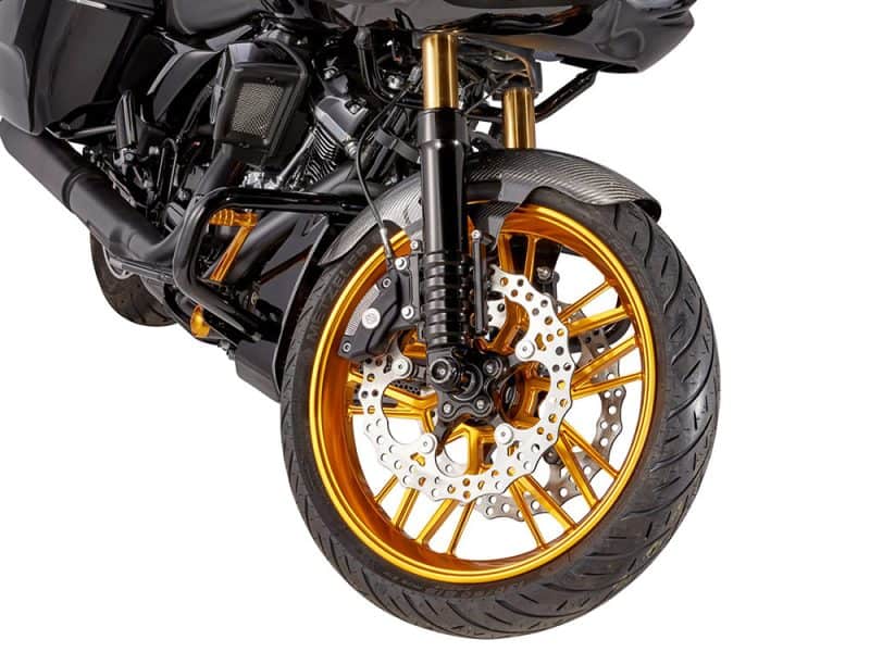 Gold motorcycle wheel and front suspension on a sleek black bike.
