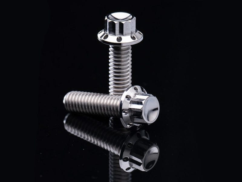 Shiny silver motorcycle bolts on reflective black background.