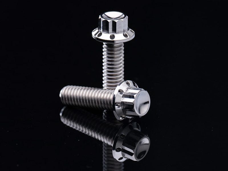 Stainless steel motorcycle bolts on black background.