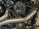 Vibrant black motorcycle engine with chrome accents and matte exhaust pipes.