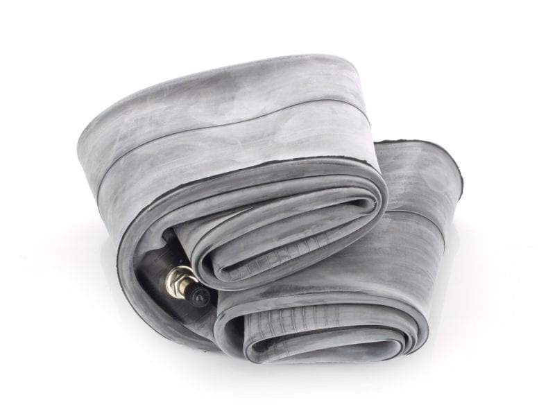 Thin, coiled motorcycle inner tube isolated on white background.