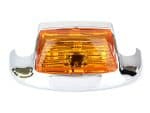 Vintage motorcycle indicator light with chrome details and amber lens.