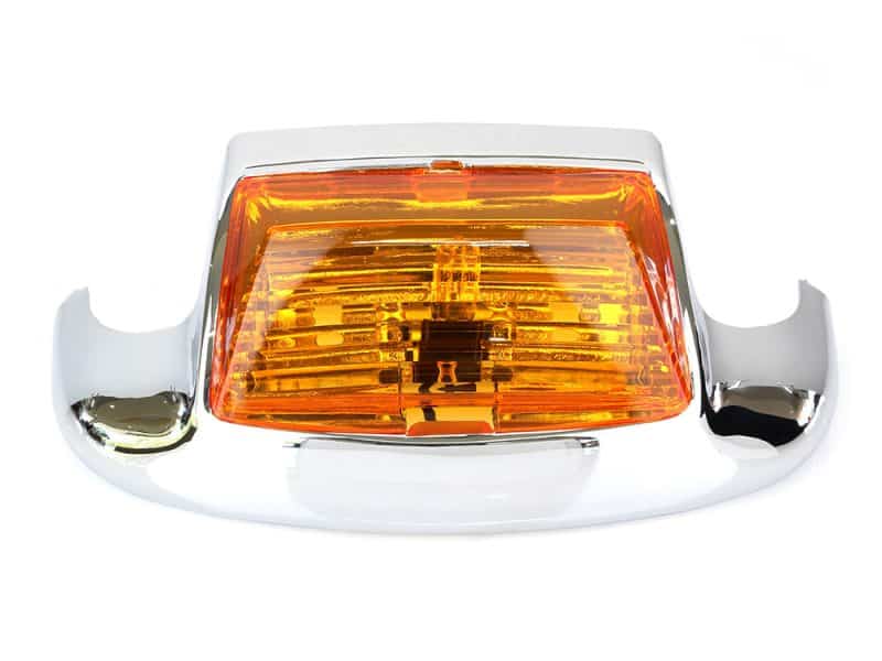 Vintage motorcycle indicator light with chrome details and amber lens.