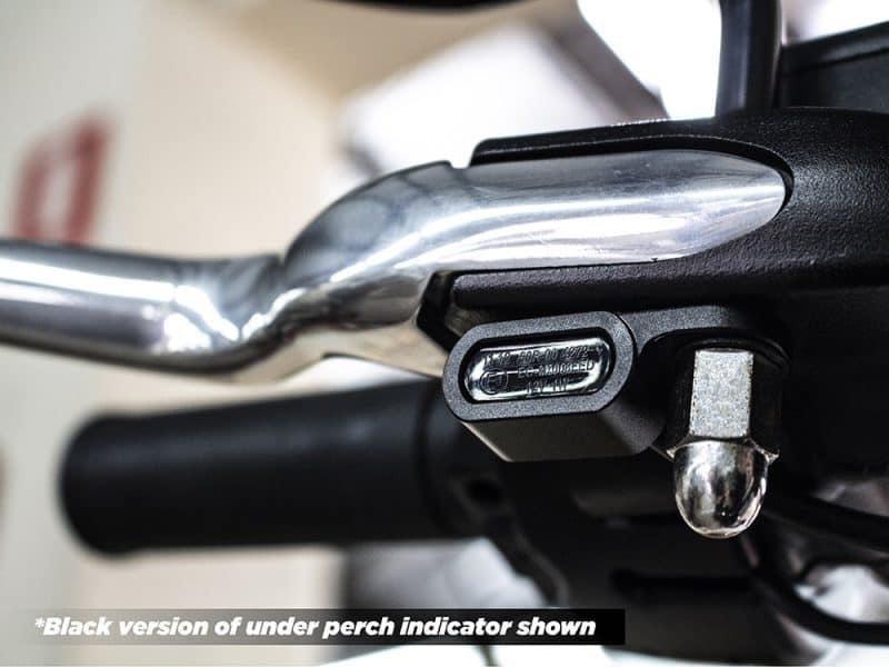 Close-up of motorcycle handlebar and electrical component at Revelry Motorcycles, showcasing quality parts.