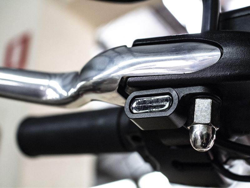 Nylon motorcycle handlebar switch with black wiring and metal bolt.