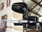 Black motorcycle mirror and handlebar close-up at Revelry Motorcycles, showcasing premium motorcycle accessories.