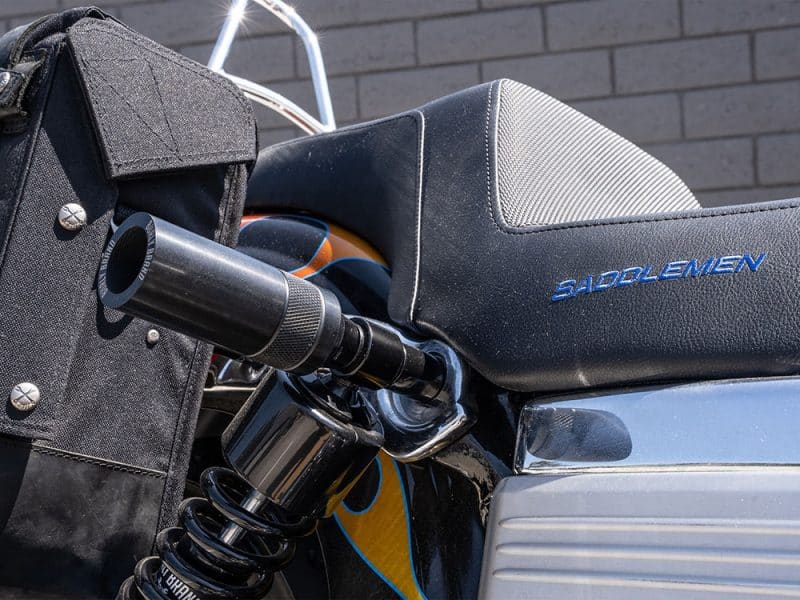 Motorcycle saddle with "Sadolmen" branding on black leather close-up.