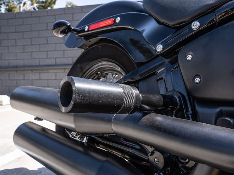 High-performance black motorcycle exhaust system at Revelry Cycles, designed for style and power.