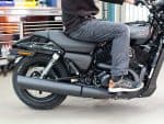 Harley Davidson motorcycle with rider in workshop for maintenance or inspection.