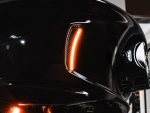 Shiny black motorcycle with illuminated tail light and sleek design, ideal for motorcycle enthusiasts.