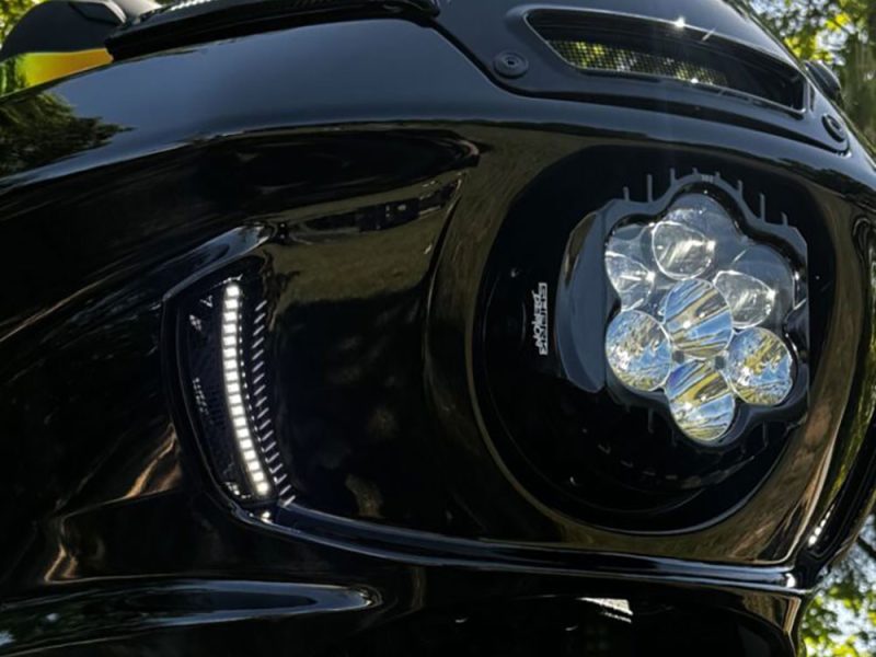 High-performance motorcycle headlight with LED lighting and sleek black design.