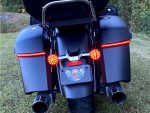 Black touring motorcycle with rear saddlebags and LED taillights, ideal for long-distance riding.