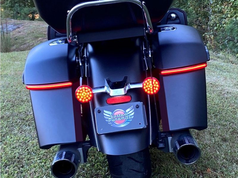 Black touring motorcycle with rear saddlebags and LED taillights, ideal for long-distance riding.