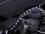 Shiny black Harley-Davidson motorcycle with LED accent lighting and leather seats for cruising.