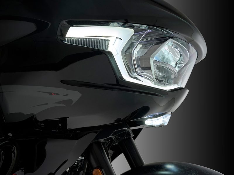 Modern black motorcycle headlight with LED daytime running lights.
