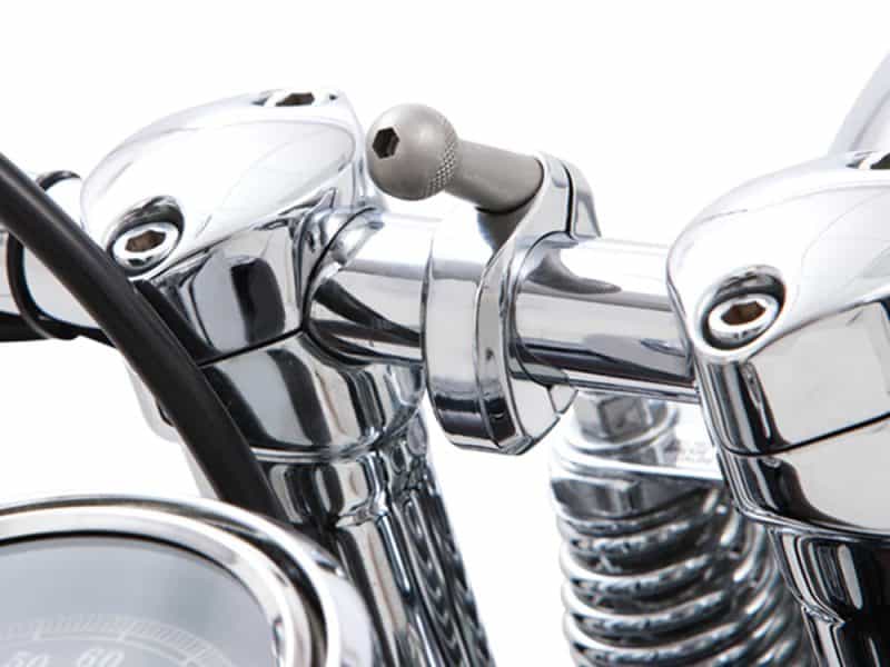 Shiny chrome motorcycle handlebar and suspension parts at Revelry Motorcycles in Australia.