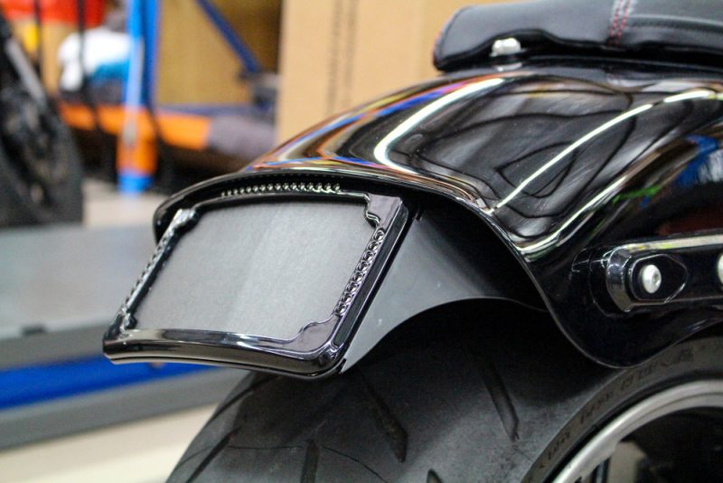 Chrome motorcycle rear fender with integrated LED license plate holder, showcasing custom bike accessories.