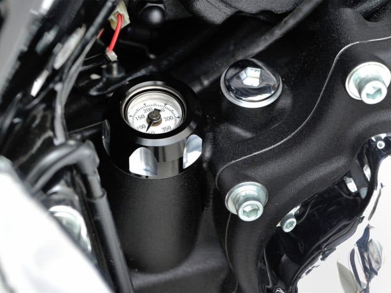 High-performance motorcycle gauge and engine components at Revelry Motorcycles shop.