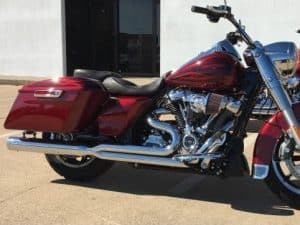 Sleek red Harley-Davidson touring motorcycle with custom exhaust and chrome details.