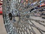 Polished chrome motorcycle wheel with intricate spoke design at Revelry Motorcycles, perfect for custom bike builds and upgrades.