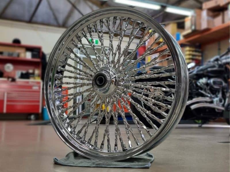 Handcrafted chrome wire-spoked motorcycle wheel for custom Harley Davidson bikes.