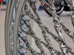 Shiny chrome motorcycle wheel spokes and rims, motorcycle parts, Revelry Motorcycles, stylish bike accessories, high-quality motorcycle design.