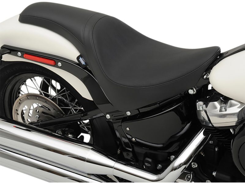 Sleek black motorcycle seat with chrome exhaust pipe - perfect for Harley Davidson enthusiasts.