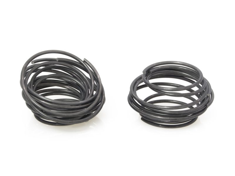 Coil springs for motorcycle suspension, black rubber shocks, high-performance bike parts.
