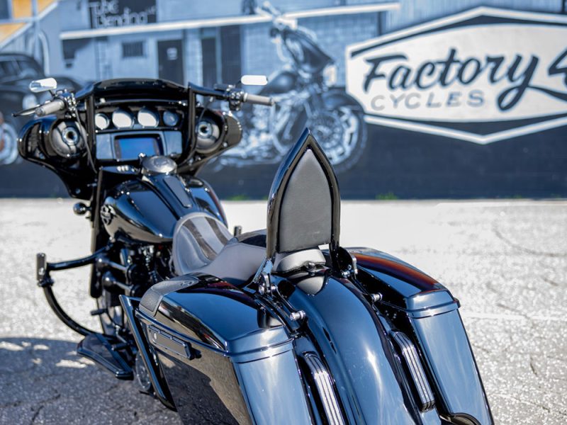 Shiny black touring motorcycle with saddlebags at Revelry Motorcycles, Australia.