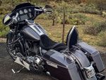 Vivid black touring motorcycle with spacious luggage, custom seat, and chrome accents for long-distance rides.