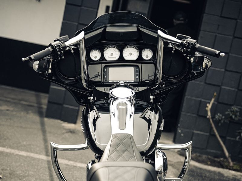 Harley Davidson touring motorcycle dashboard with modern instruments and navigation system controlled via handlebar controls.