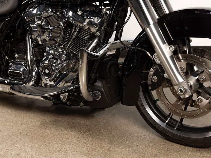 Shiny black and chrome motorcycle engine with custom parts and large front disc brake, showcasing quality craftsmanship.