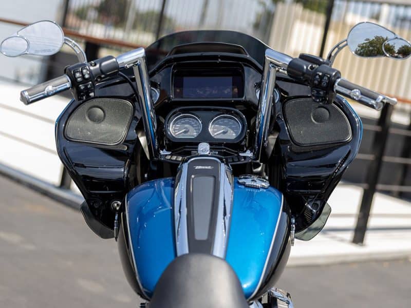 Shiny black and blue Harley Davidson motorcycle dashboard with handlebars and mirrors.