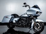 Harley-Davidson touring motorcycle with silver finish and custom black exhaust pipes.
