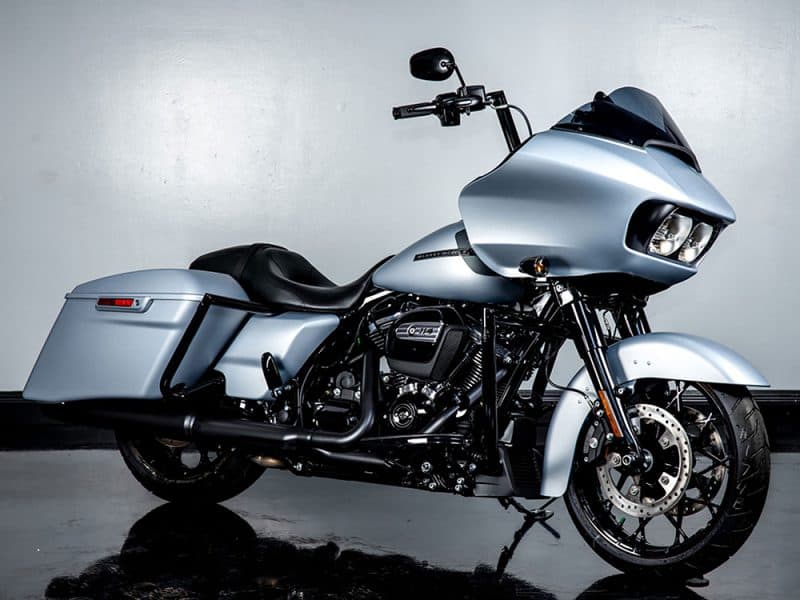Harley-Davidson touring motorcycle with silver finish and custom black exhaust pipes.