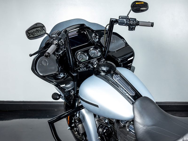 Shiny black and silver Harley-Davidson touring motorcycle with digital dashboard and mirrors.