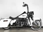 Harley-Davidson touring motorcycle with custom white and black paint in a showroom setting.