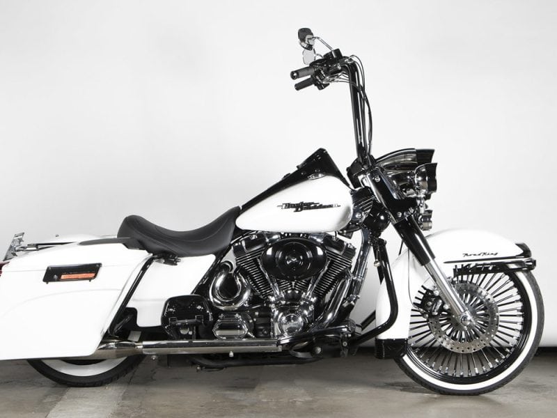 Harley-Davidson touring motorcycle with custom white and black paint in a showroom setting.