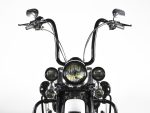 Motorcycle handlebars with headlight and mirrors, classic cruiser style, black and chrome details.