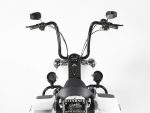 Vintage cruiser motorcycle handlebar with black and white colour scheme, chrome accents, and wide mirrors.